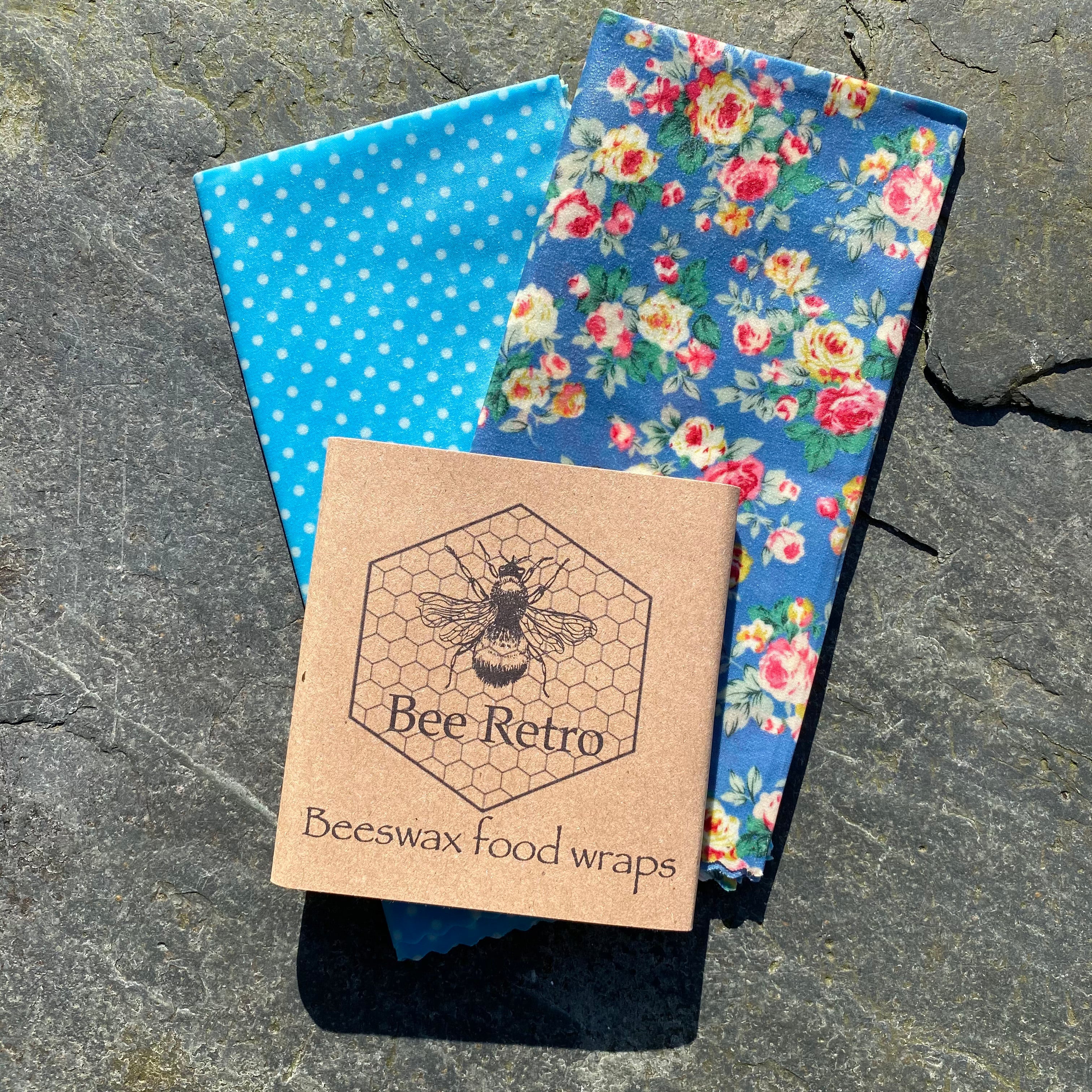 Blue chintz floral pattern reusable beeswax food wrap covering a bowl and wrapping a sandwich — view 3