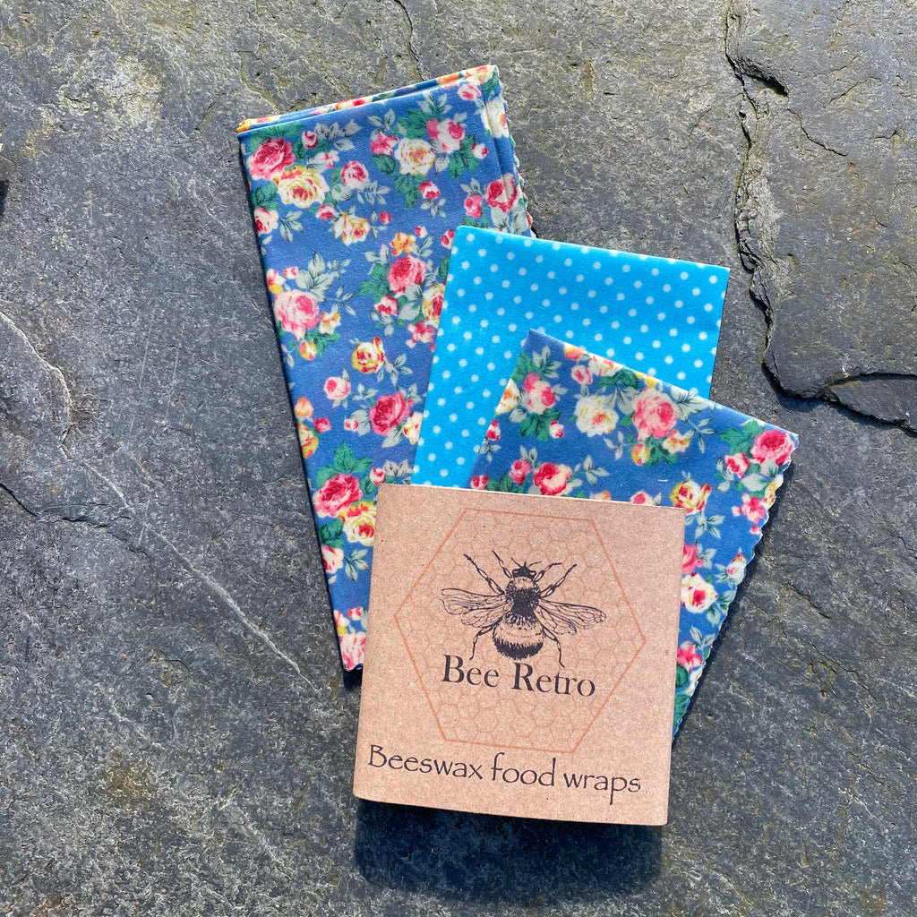 Blue chintz floral pattern reusable beeswax food wrap covering a bowl and wrapping a sandwich — view 5