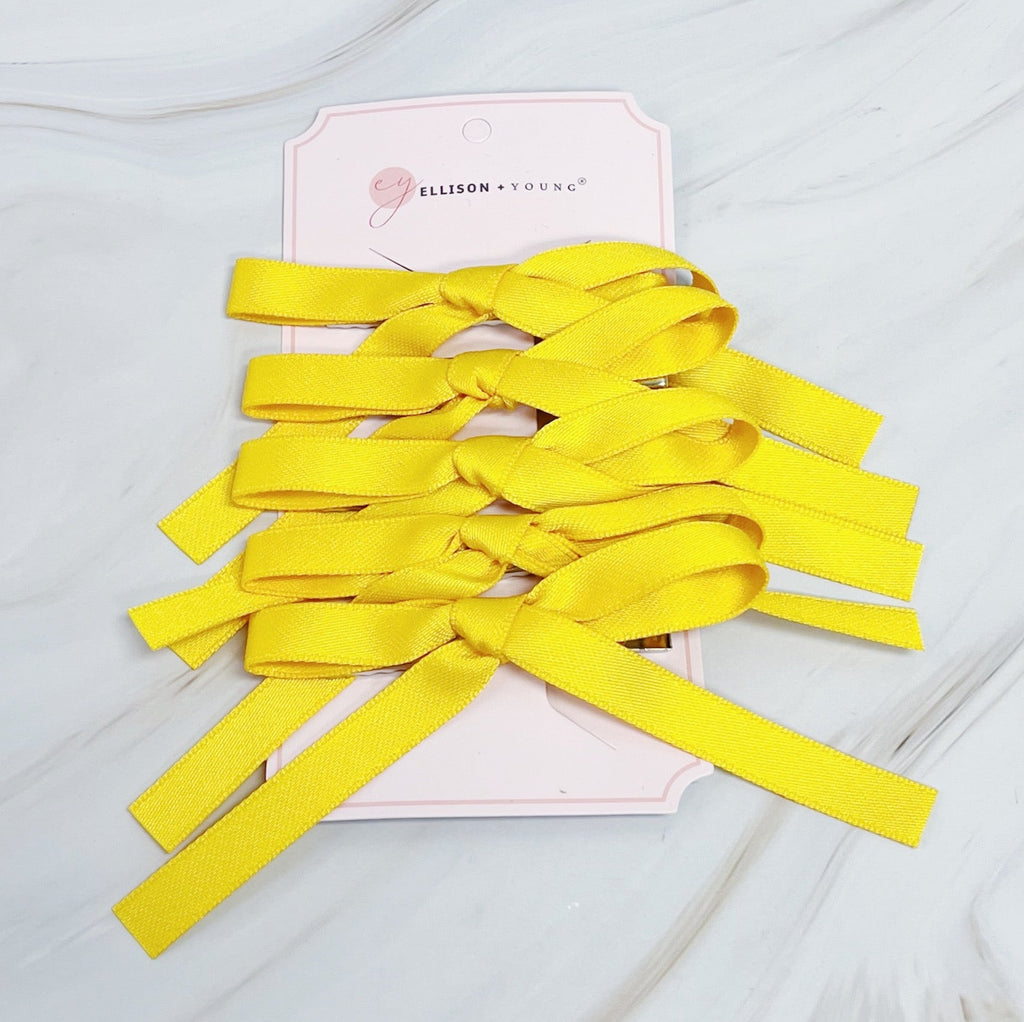 Set of five solid color bow hair clips arranged together, 5 inches wide with medium hold — view 3