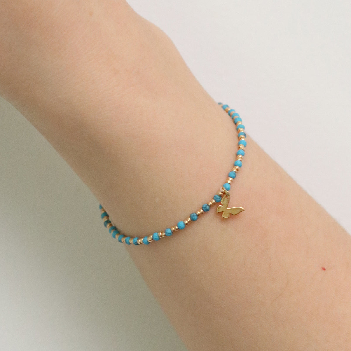 Gemstone butterfly charm stretch bracelet with delicate beads and a miniature metallic butterfly pendant — view 3