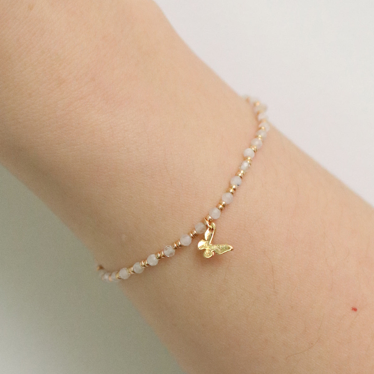 Gemstone butterfly charm stretch bracelet with delicate beads and a miniature metallic butterfly pendant — view 4