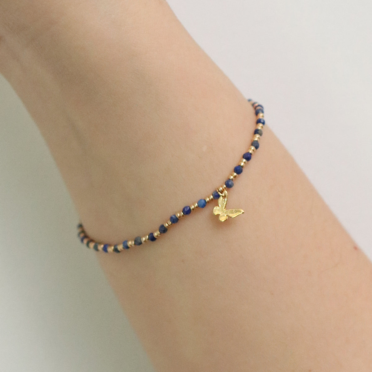Gemstone butterfly charm stretch bracelet with delicate beads and a miniature metallic butterfly pendant — view 5
