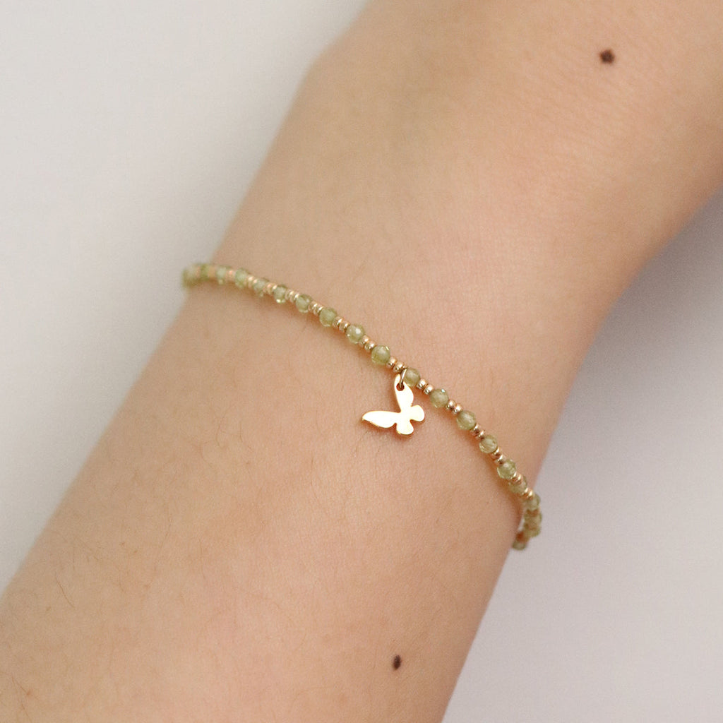 Gemstone butterfly charm stretch bracelet with delicate beads and a miniature metallic butterfly pendant
