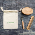 On-the-go bamboo hair brush set with detangling comb, cleaning tool, and reusable travel bag.