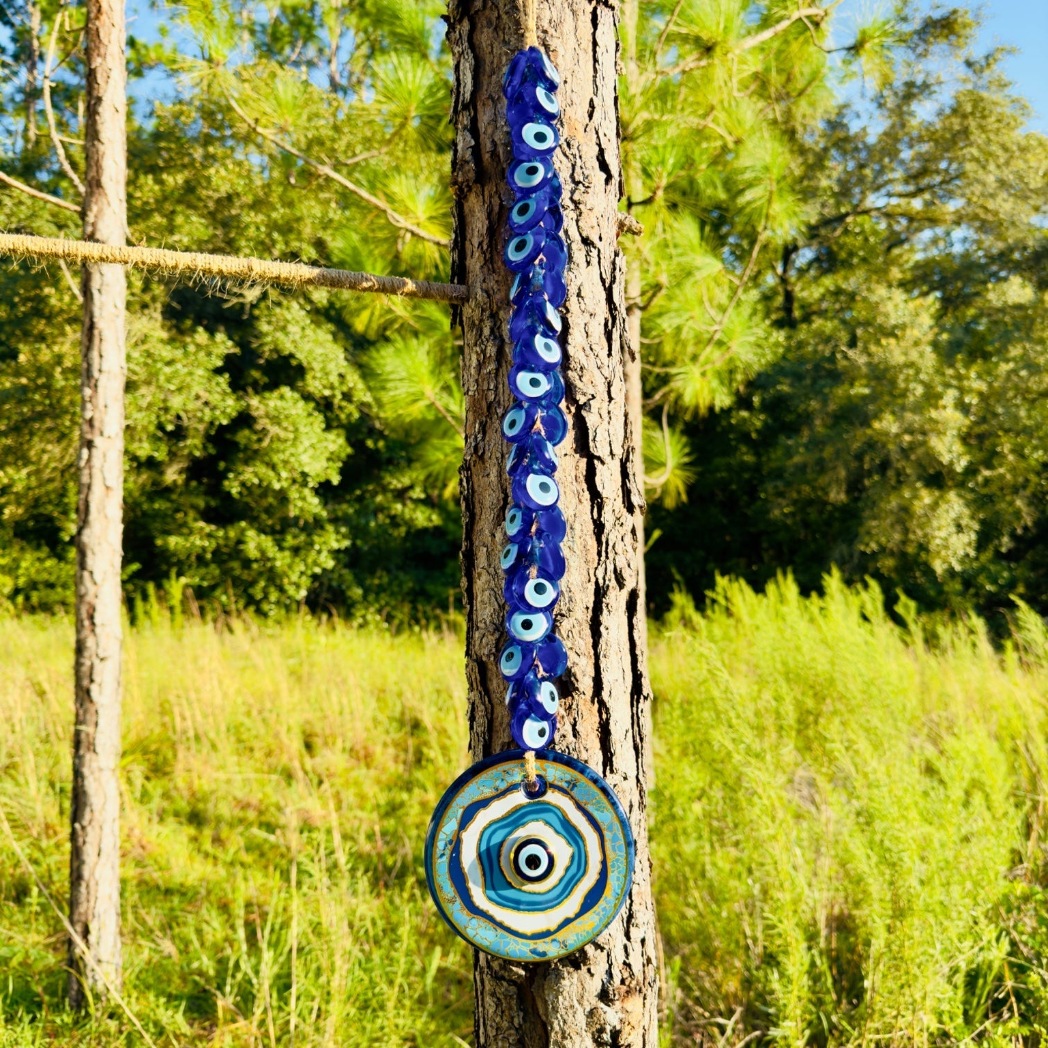 Macrame evil eye wall decor featuring a large handblown blue glass pendant and woven beads — view 2
