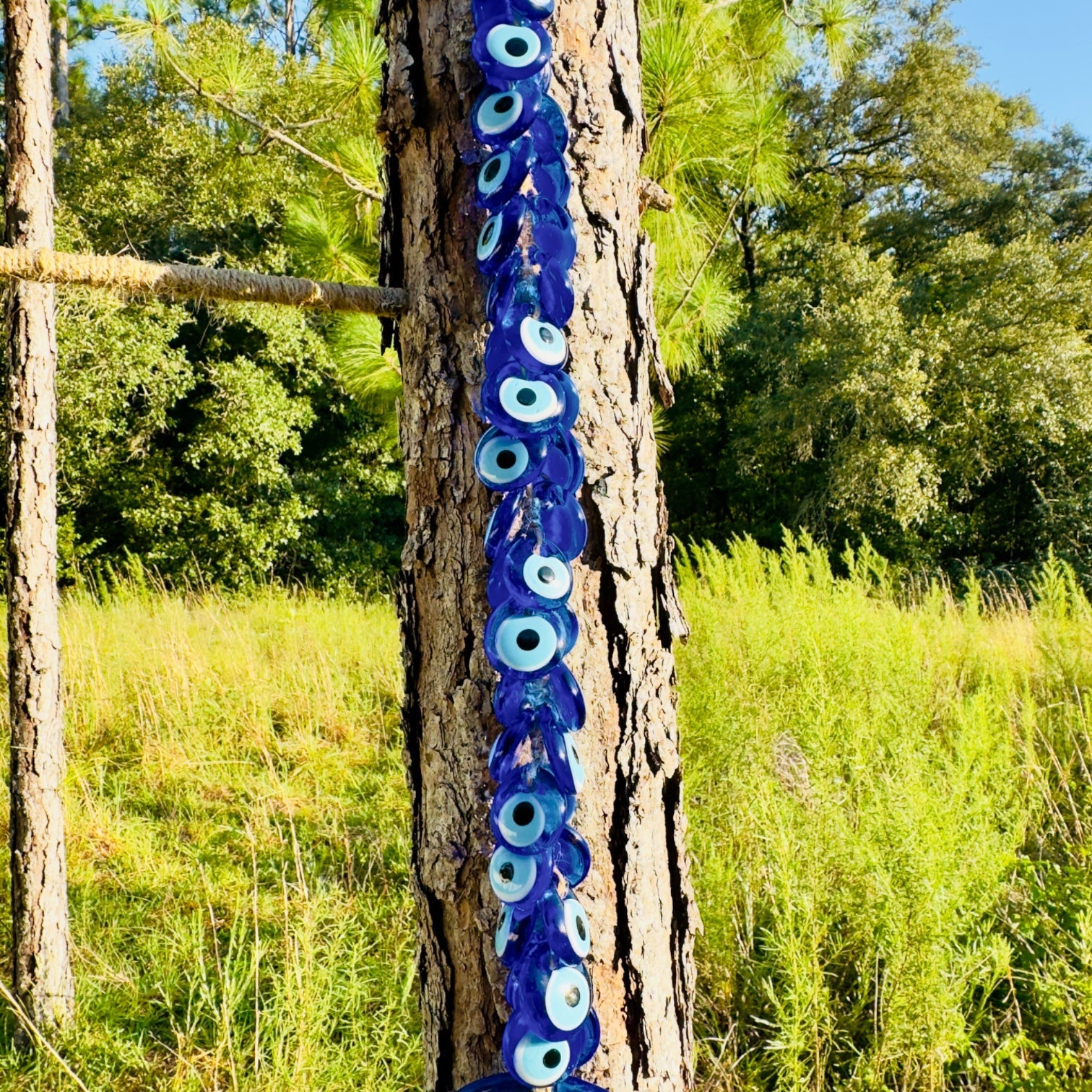 Macrame evil eye wall decor featuring a large handblown blue glass pendant and woven beads — view 4