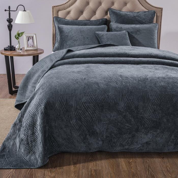 Navy blue velvet cushion cover with wavy matelassé stitching shown styled on a bedroom bed. — view 5