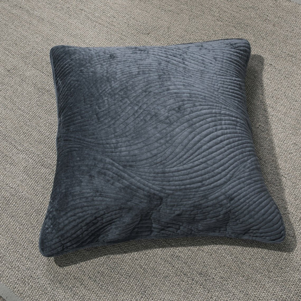 Navy blue velvet cushion cover with wavy matelassé stitching shown styled on a bedroom bed. — view 3