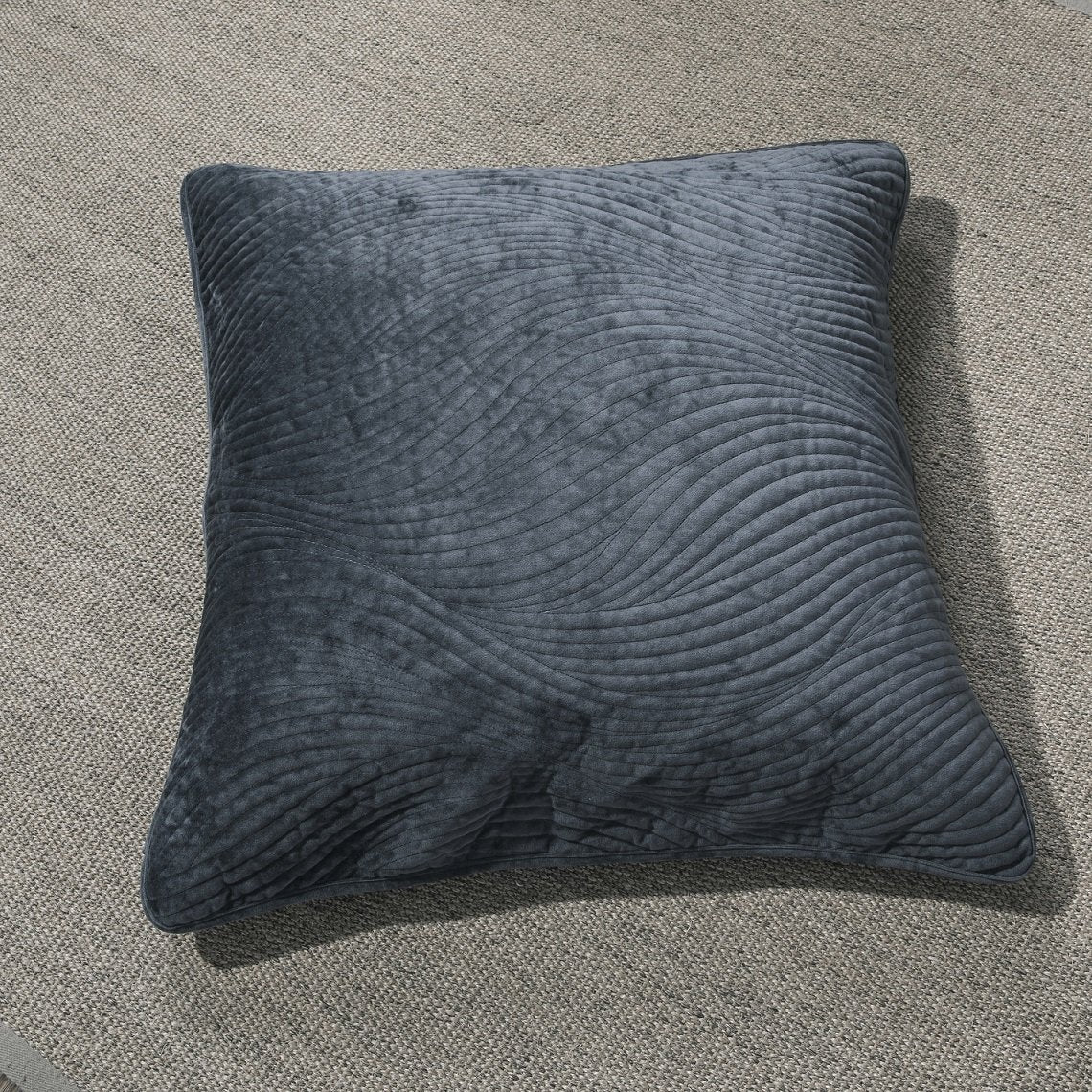 Navy blue velvet cushion cover with wavy matelassé stitching shown styled on a bedroom bed. — view 3