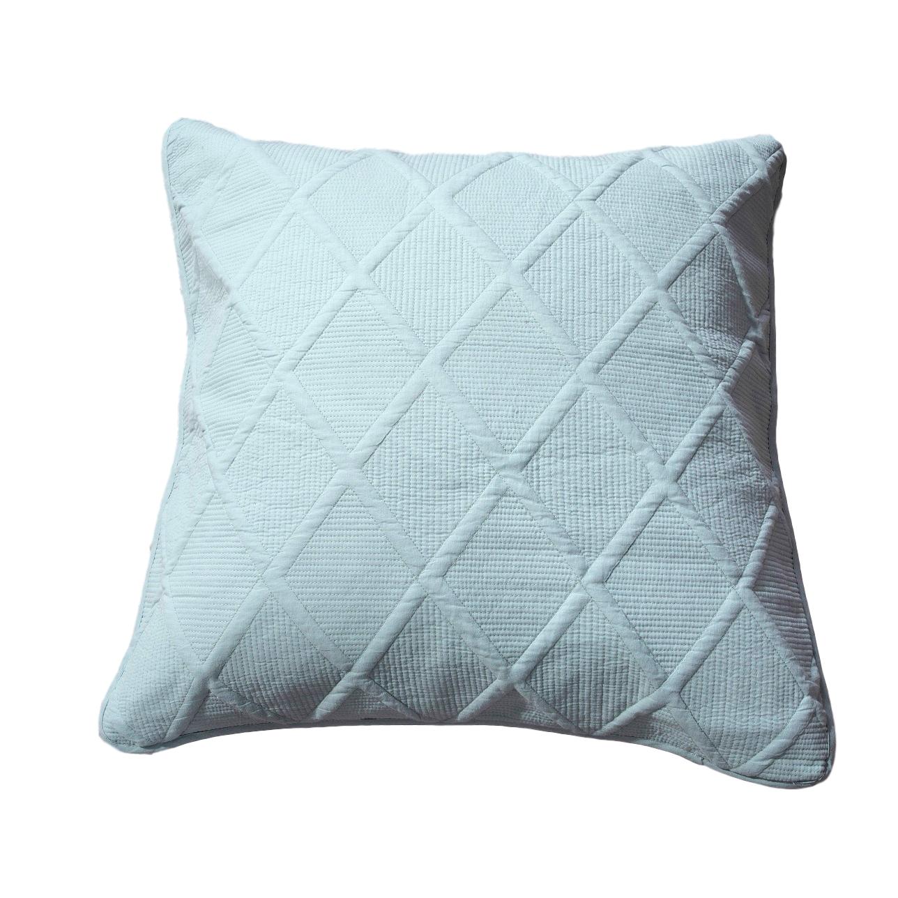 Seafoam blue cotton cushion cover with geometric diamond matelasse stitching on a comfortable bed