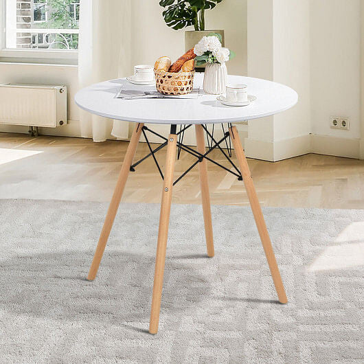 White round modern dining table with solid beech wood legs on a clean hardwood floor — view 2