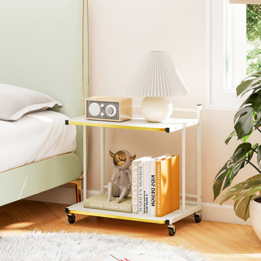 White two-tier mobile side table with golden trim, open shelves, and rolling casters — view 2