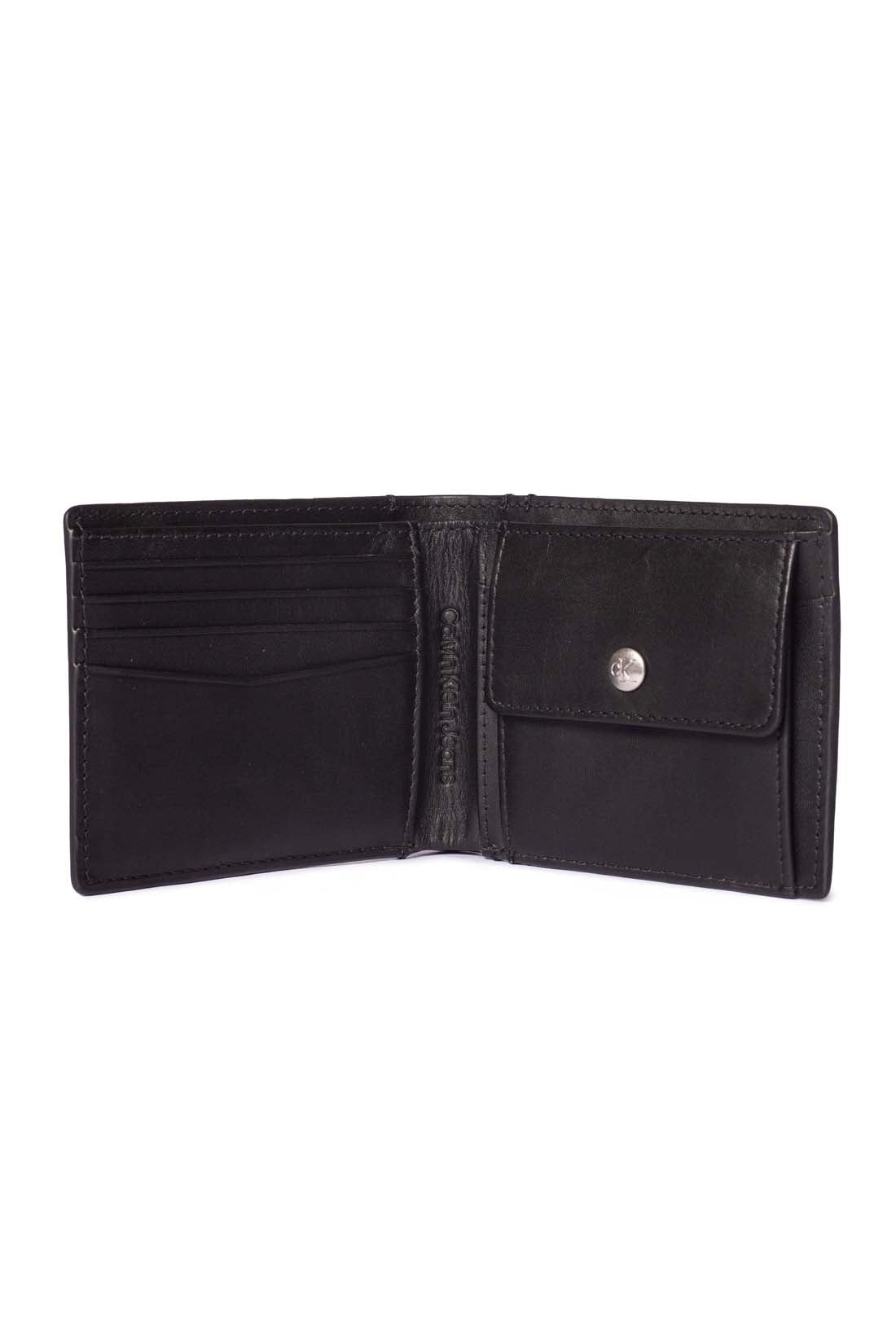 Black leather men's bifold wallet with monogram plaquette, card slots, and snap coin pocket. — view 6