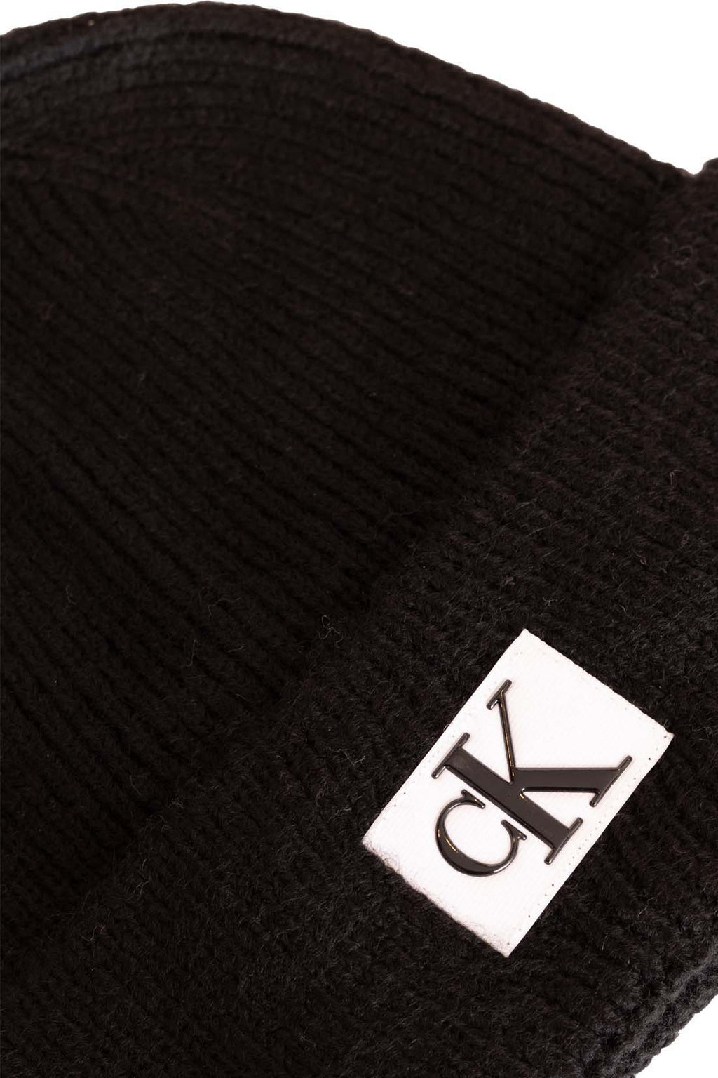 Men's black ribbed knit beanie with folded cuff and front designer logo patch. — view 2