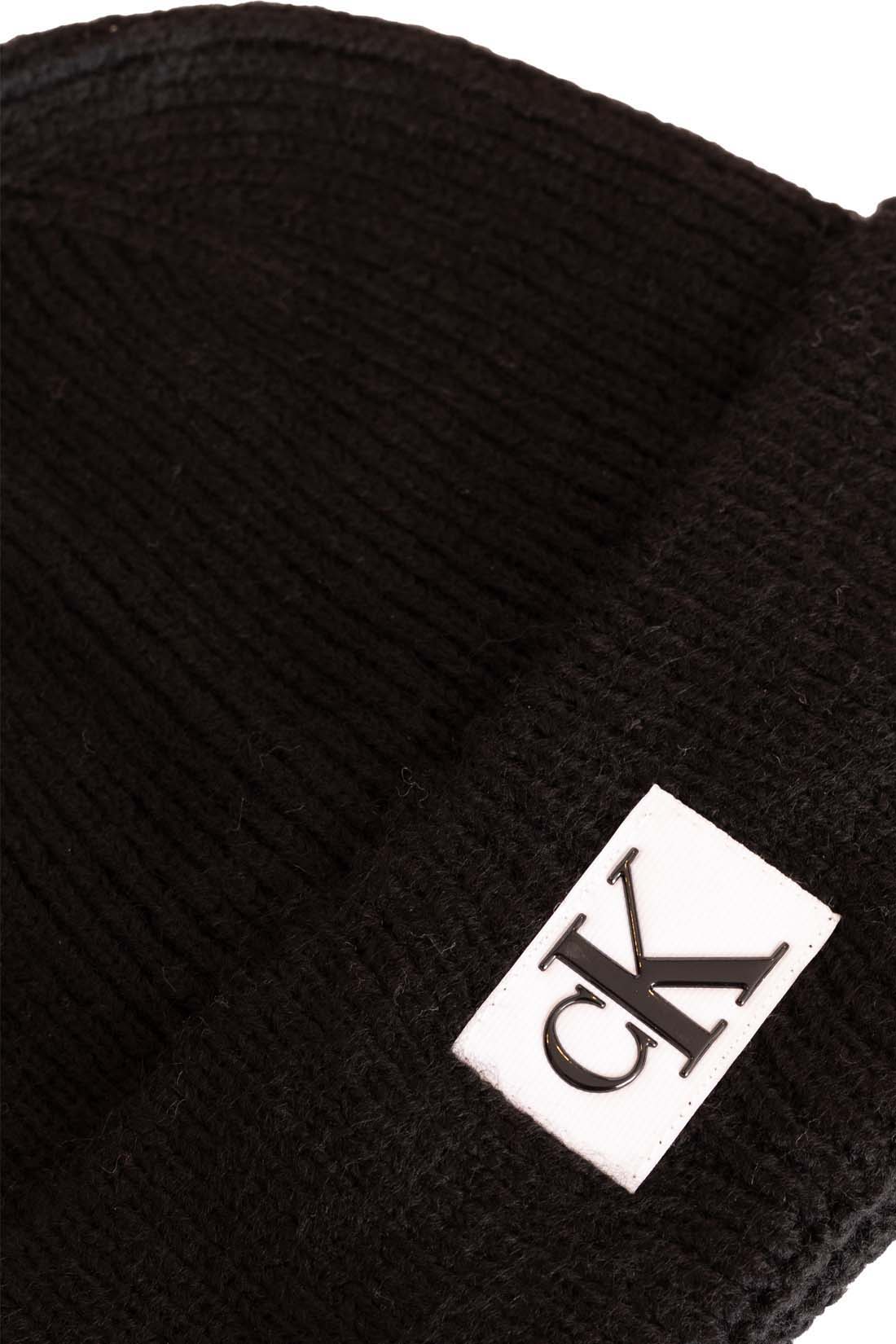 Men's black ribbed knit beanie with folded cuff and front designer logo patch. — view 2