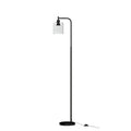 Modern black metal floor lamp with glass shade illuminating a stylish living room setting