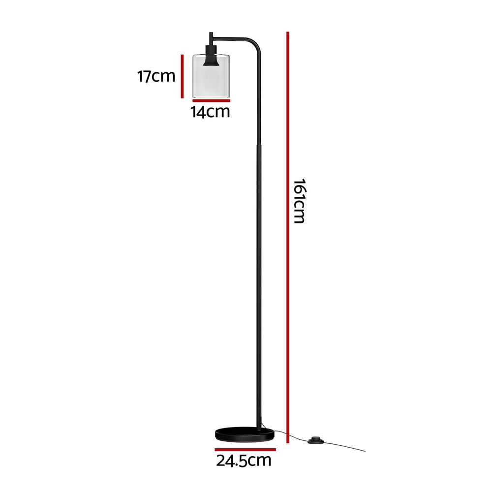 Modern black metal floor lamp with glass shade illuminating a stylish living room setting — view 2