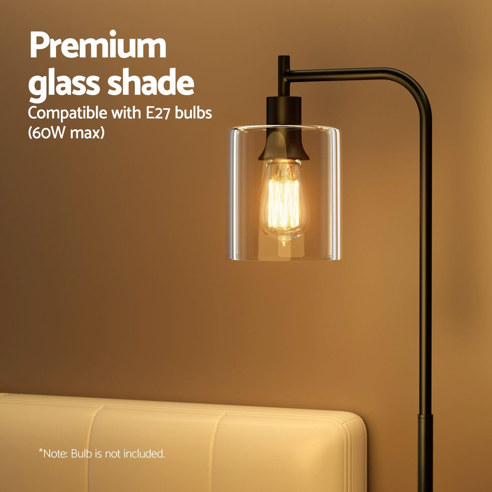 Modern black metal floor lamp with glass shade illuminating a stylish living room setting — view 5
