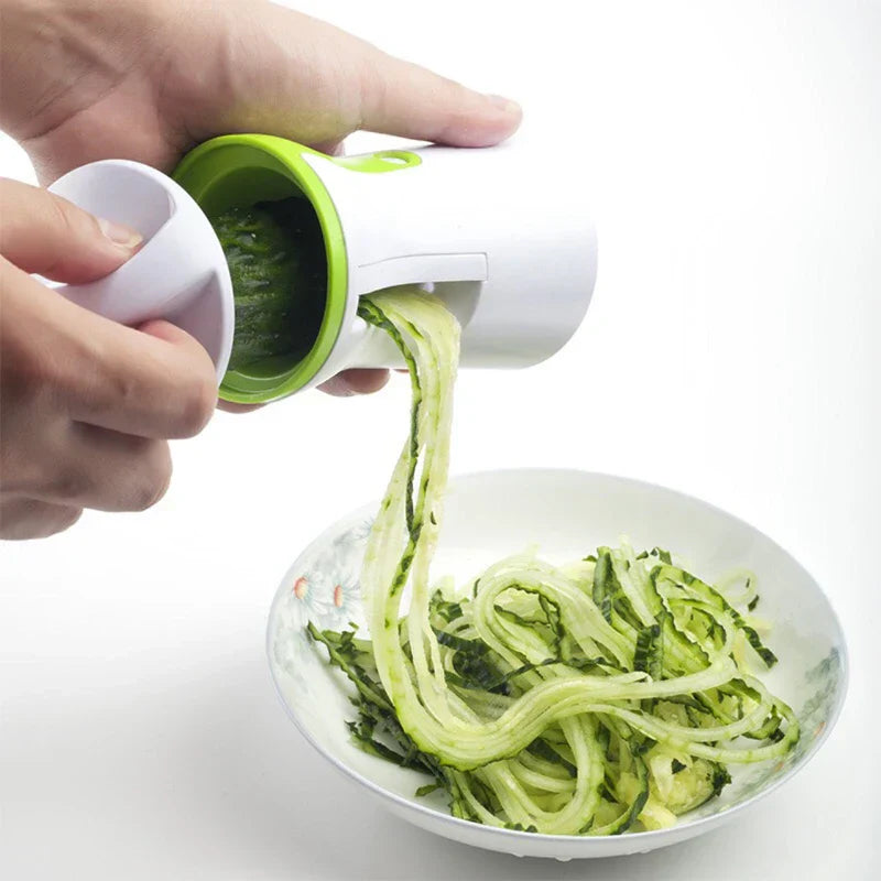 Heavy duty stainless steel vegetable spiralizer slicing a fresh green zucchini into curly vegetable pasta noodles