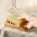Natural wooden soap dish with horizontal drainage slots and non slip base for bathroom sinks