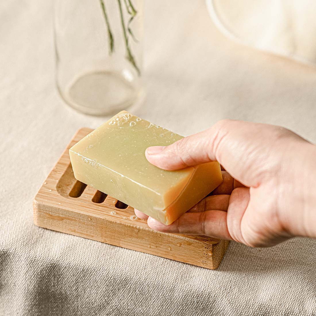 Natural wooden soap dish with horizontal drainage slots and non slip base for bathroom sinks