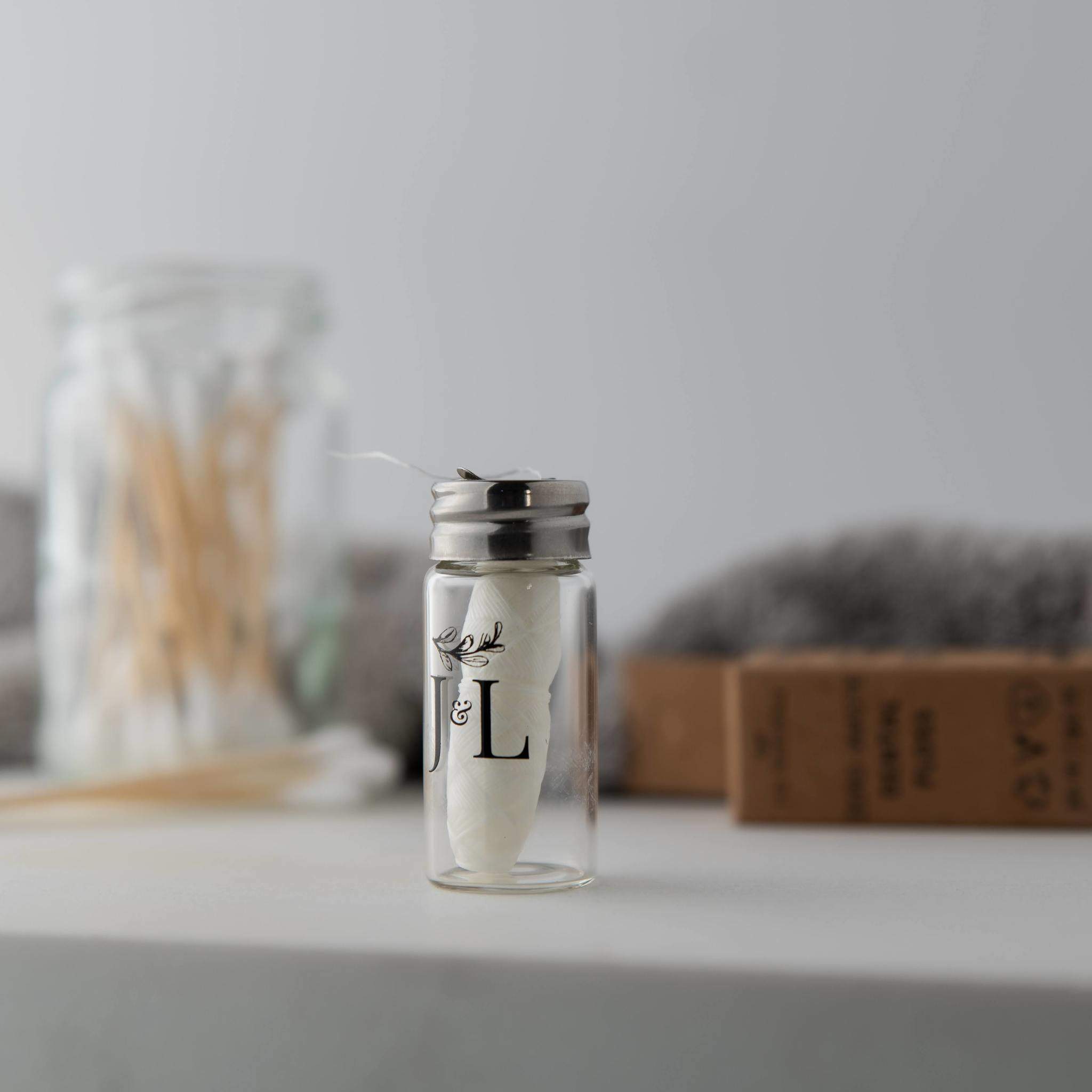 Biodegradable mint dental floss roll in a reusable clear glass dispenser bottle for sustainable oral care — view 2