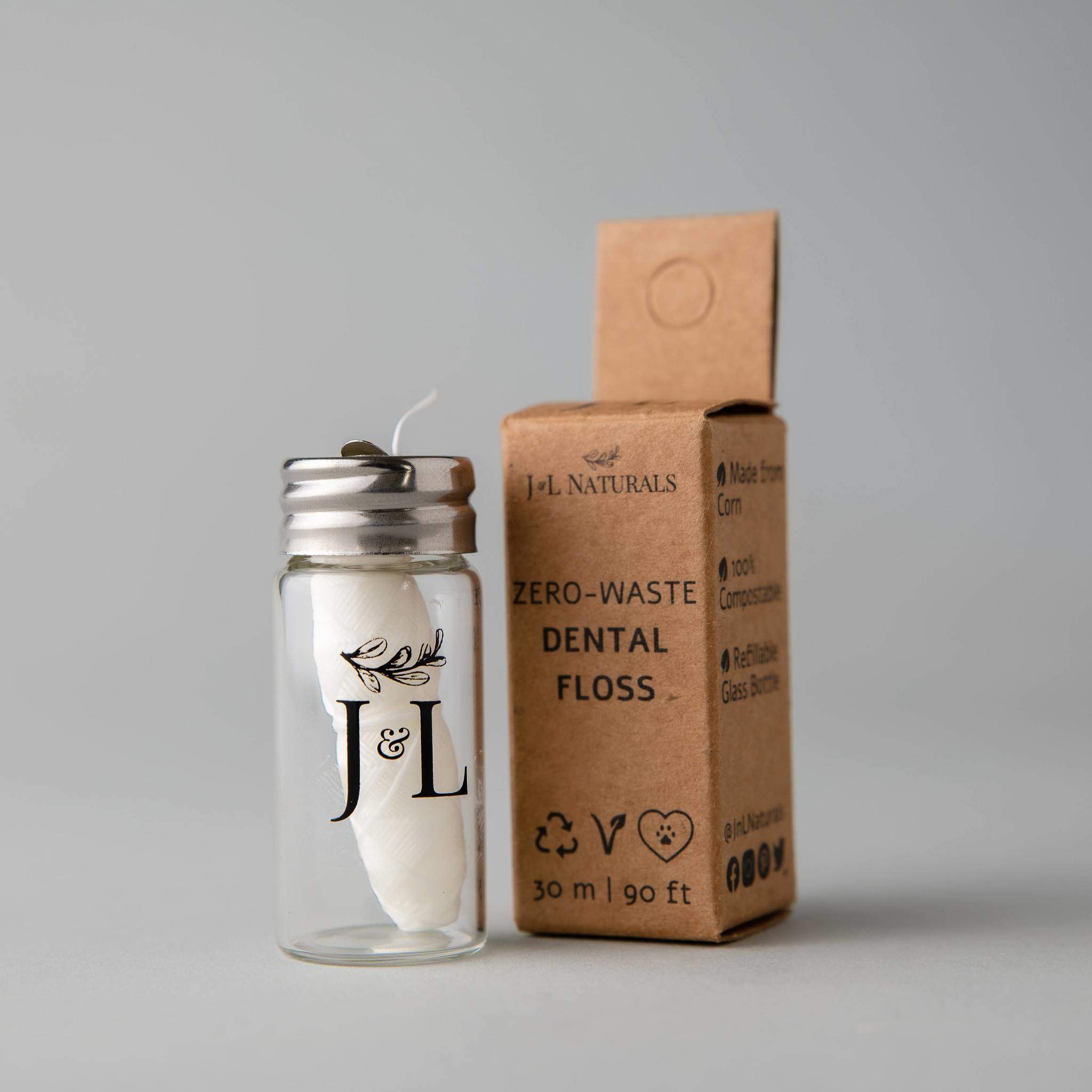 Biodegradable mint dental floss roll in a reusable clear glass dispenser bottle for sustainable oral care — view 3
