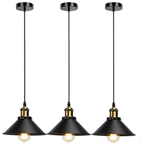 Three black industrial metal pendant lights hanging over a dining table with vintage Edison bulbs. — view 4