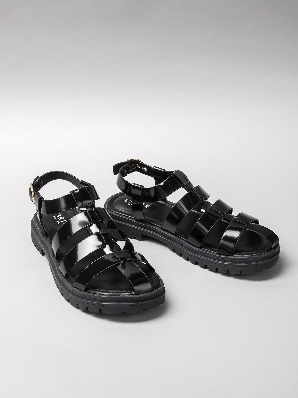 Pair of black women's sandals featuring minimalist synthetic straps and a comfortable flat walking sole — view 2