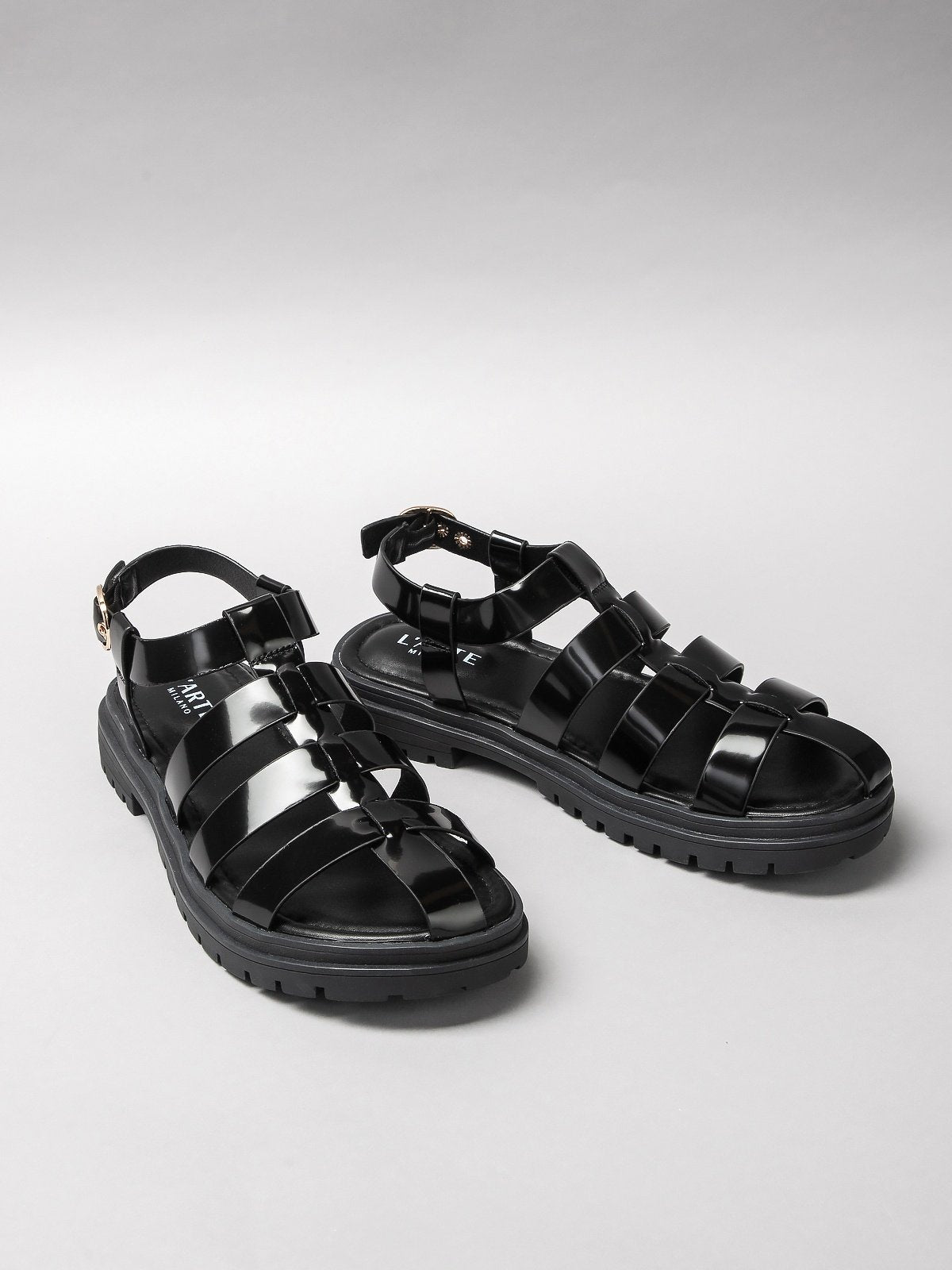 Pair of black women's sandals featuring minimalist synthetic straps and a comfortable flat walking sole — view 2