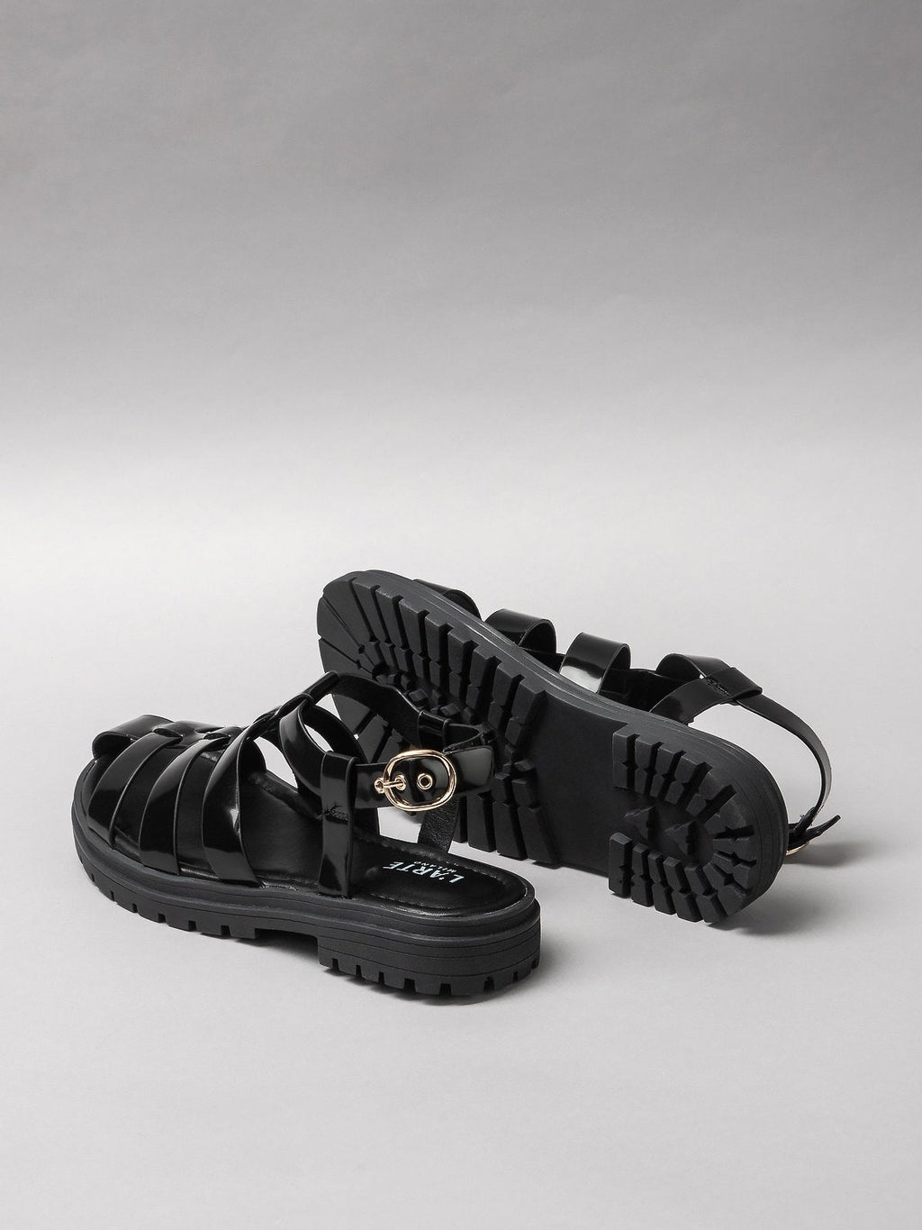 Pair of black women's sandals featuring minimalist synthetic straps and a comfortable flat walking sole — view 3