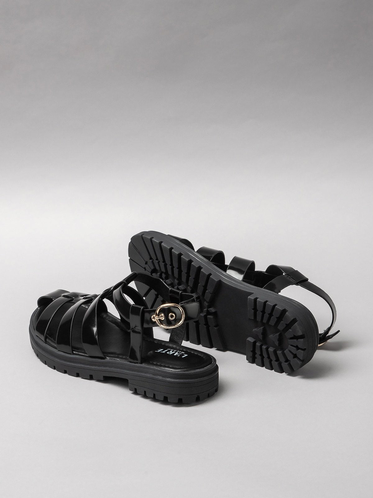 Pair of black women's sandals featuring minimalist synthetic straps and a comfortable flat walking sole — view 3