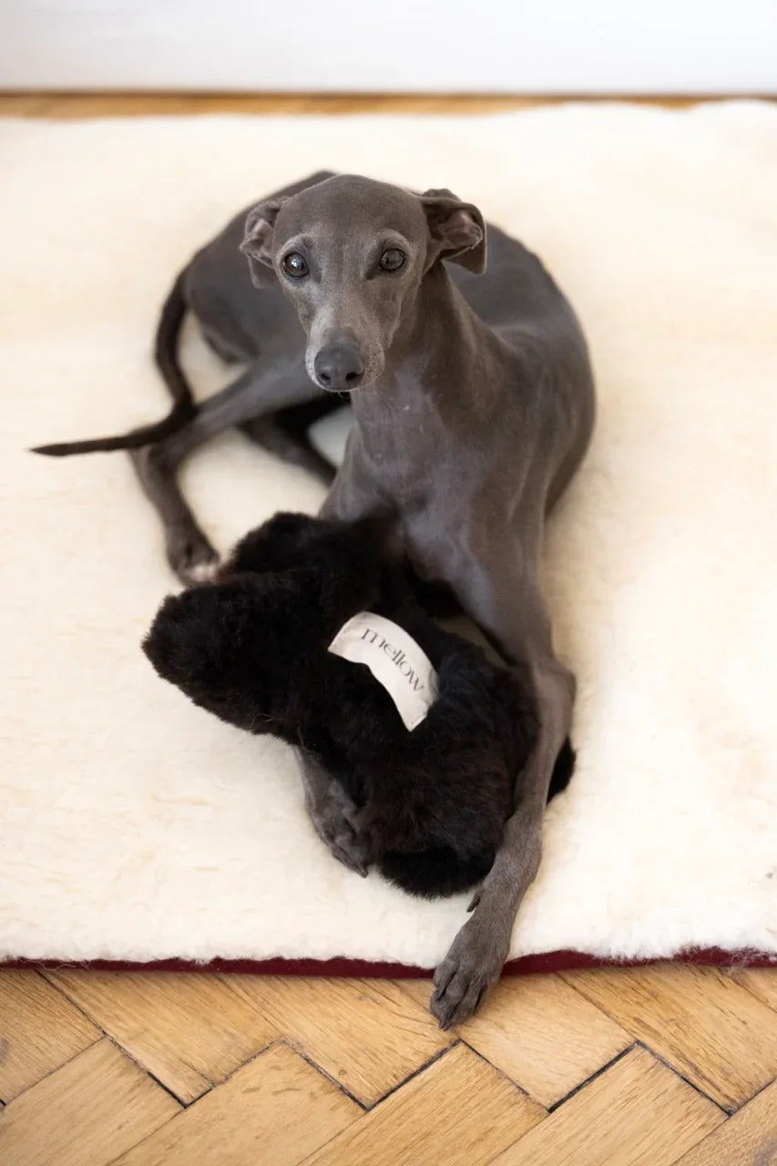 Natural sheepskin dog toy bone in black, filled with eco-friendly wool offcuts and hidden bell — view 4