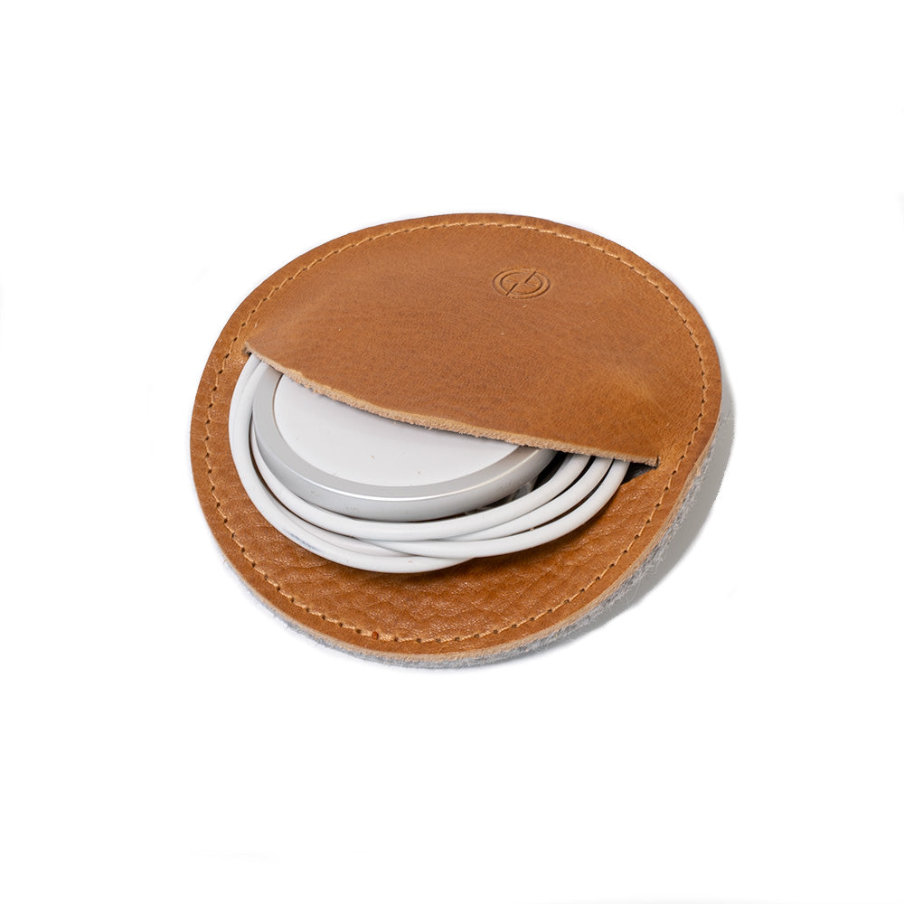 Premium leather cord organizer holding an Apple MagSafe charger in a compact round design