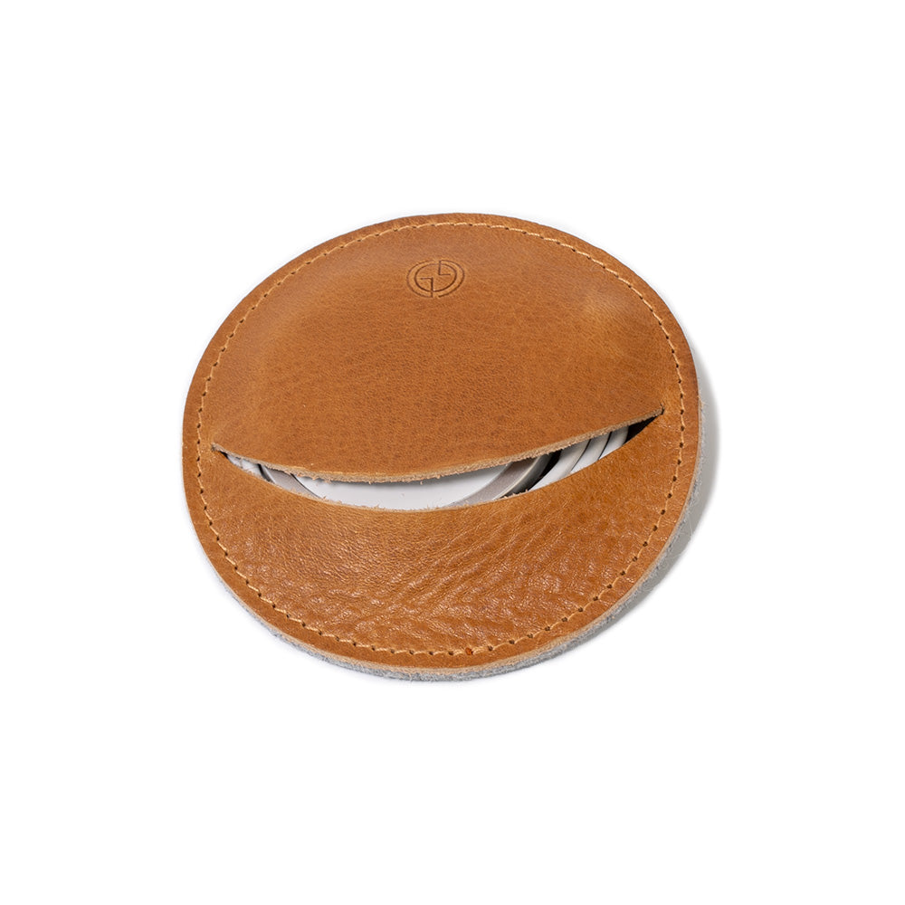 Premium leather cord organizer holding an Apple MagSafe charger in a compact round design — view 2