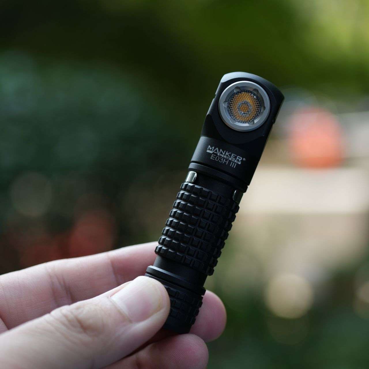 Black compact Manker E03H III flashlight and headlamp with elastic headband and attachable colored filters — view 2