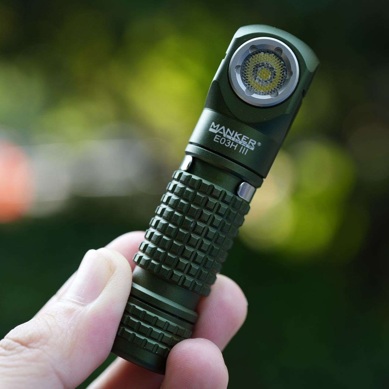 Black compact Manker E03H III flashlight and headlamp with elastic headband and attachable colored filters — view 3