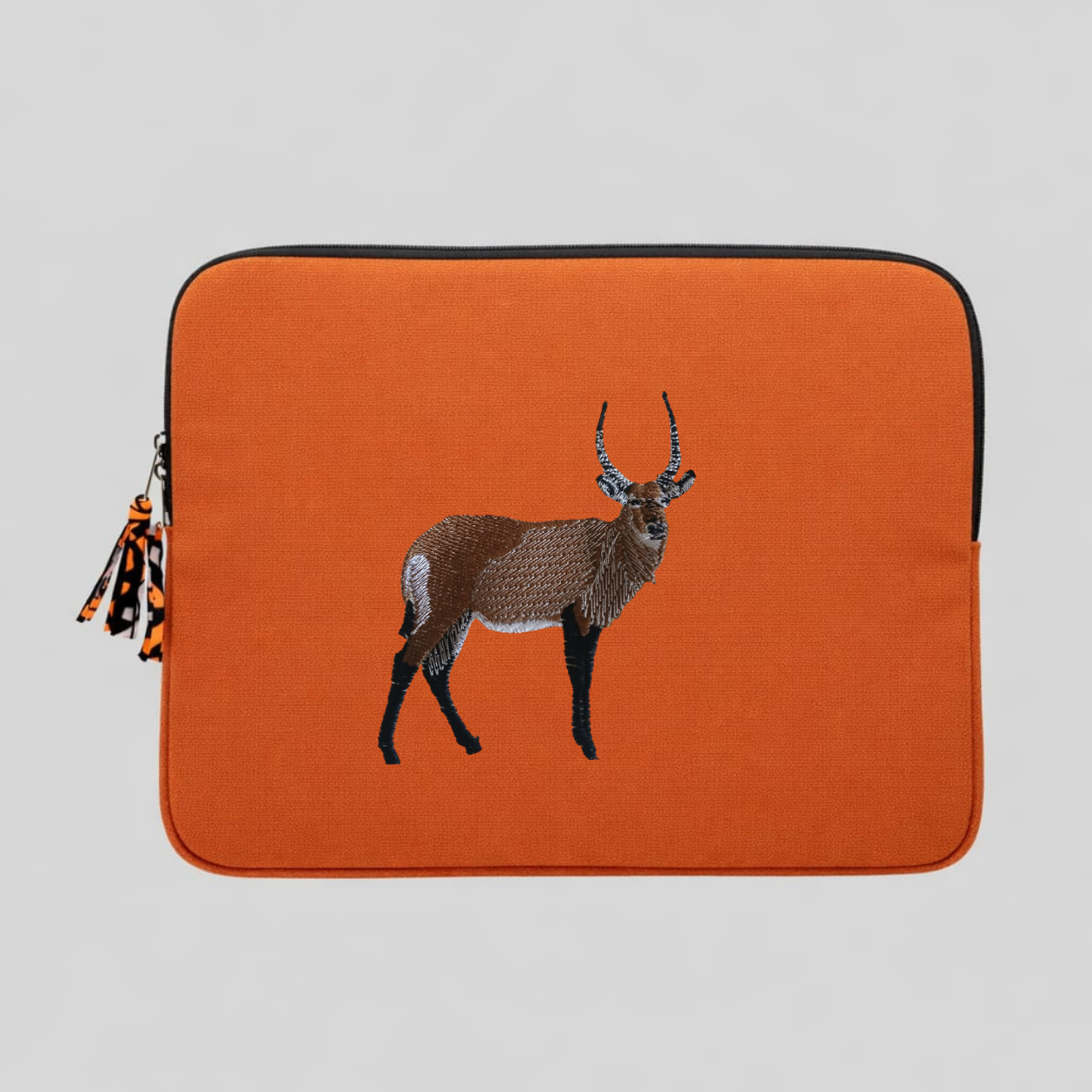 Handmade Kenyan cotton canvas laptop sleeve featuring embroidered African wildlife design in warm earthy tones — view 4