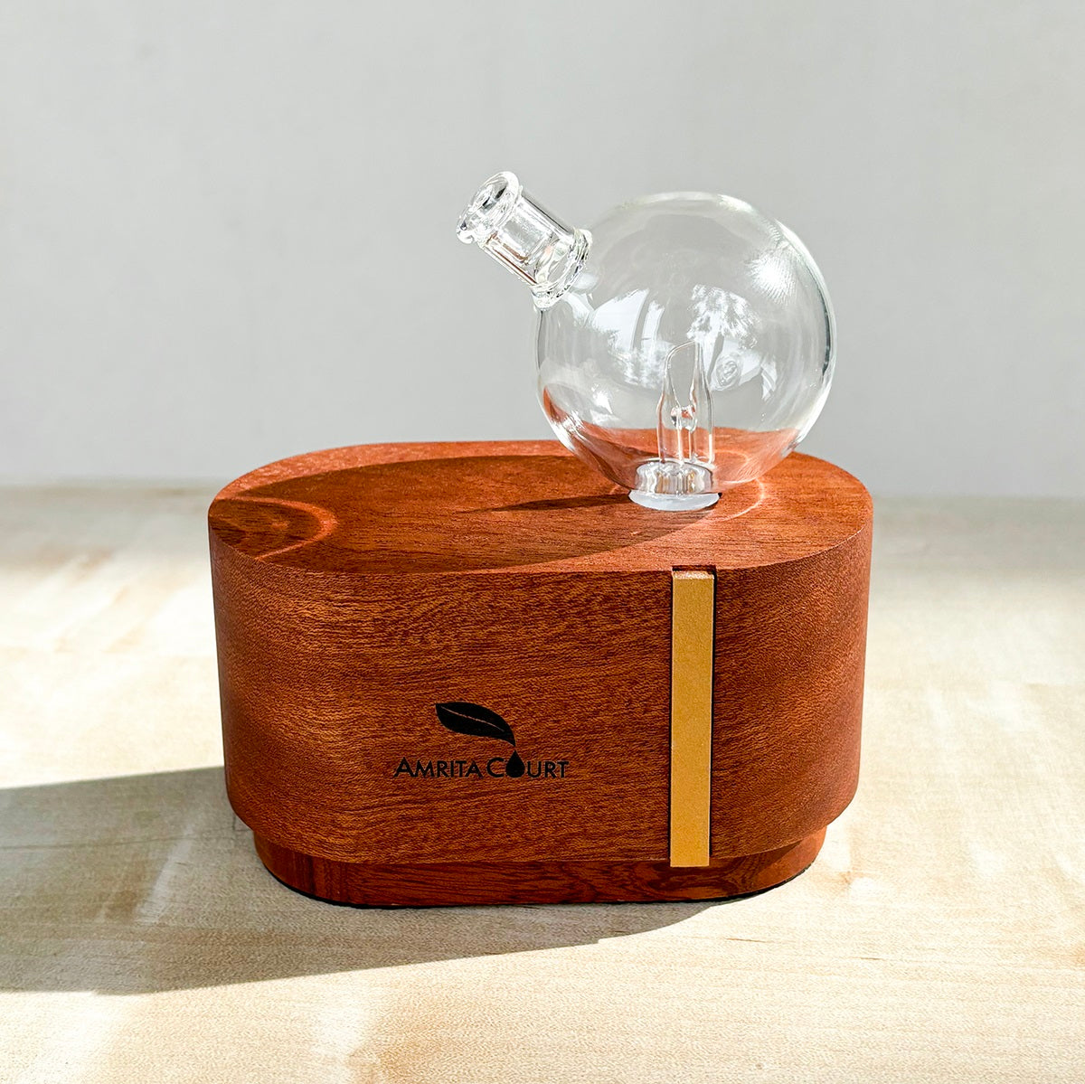 Portable waterless essential oil diffuser made of hand blown glass and African red wood base