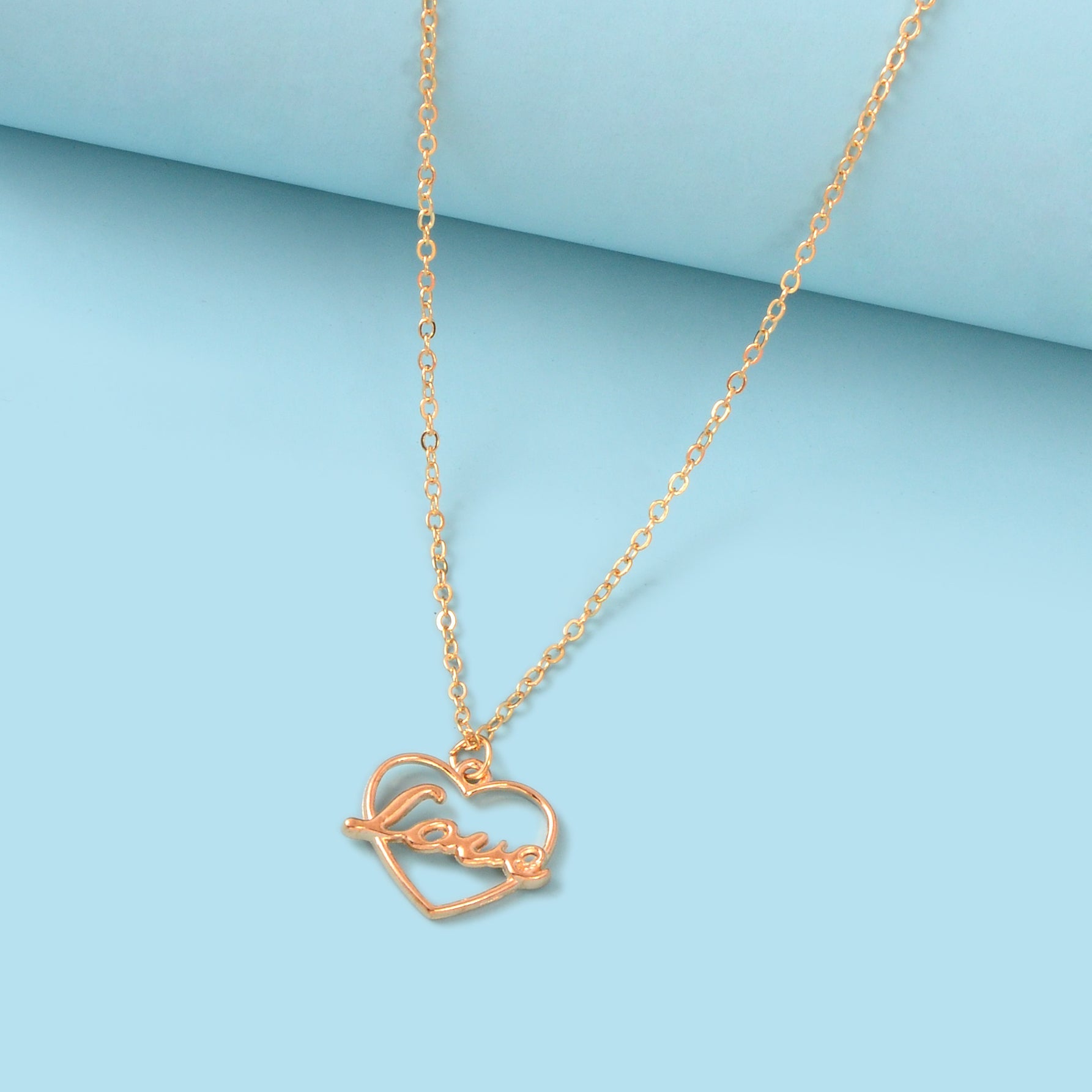 Gold-tone LOVE letter pendant necklace with a delicate heart motif on a classic link chain — view 2