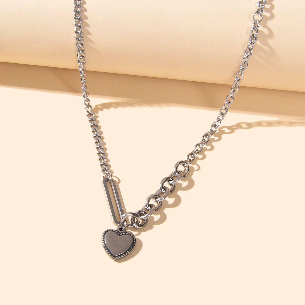 Layered multiple silver chain necklace featuring a polished love heart charm pendant on a display — view 2