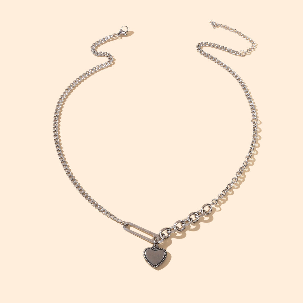 Layered multiple silver chain necklace featuring a polished love heart charm pendant on a display — view 3