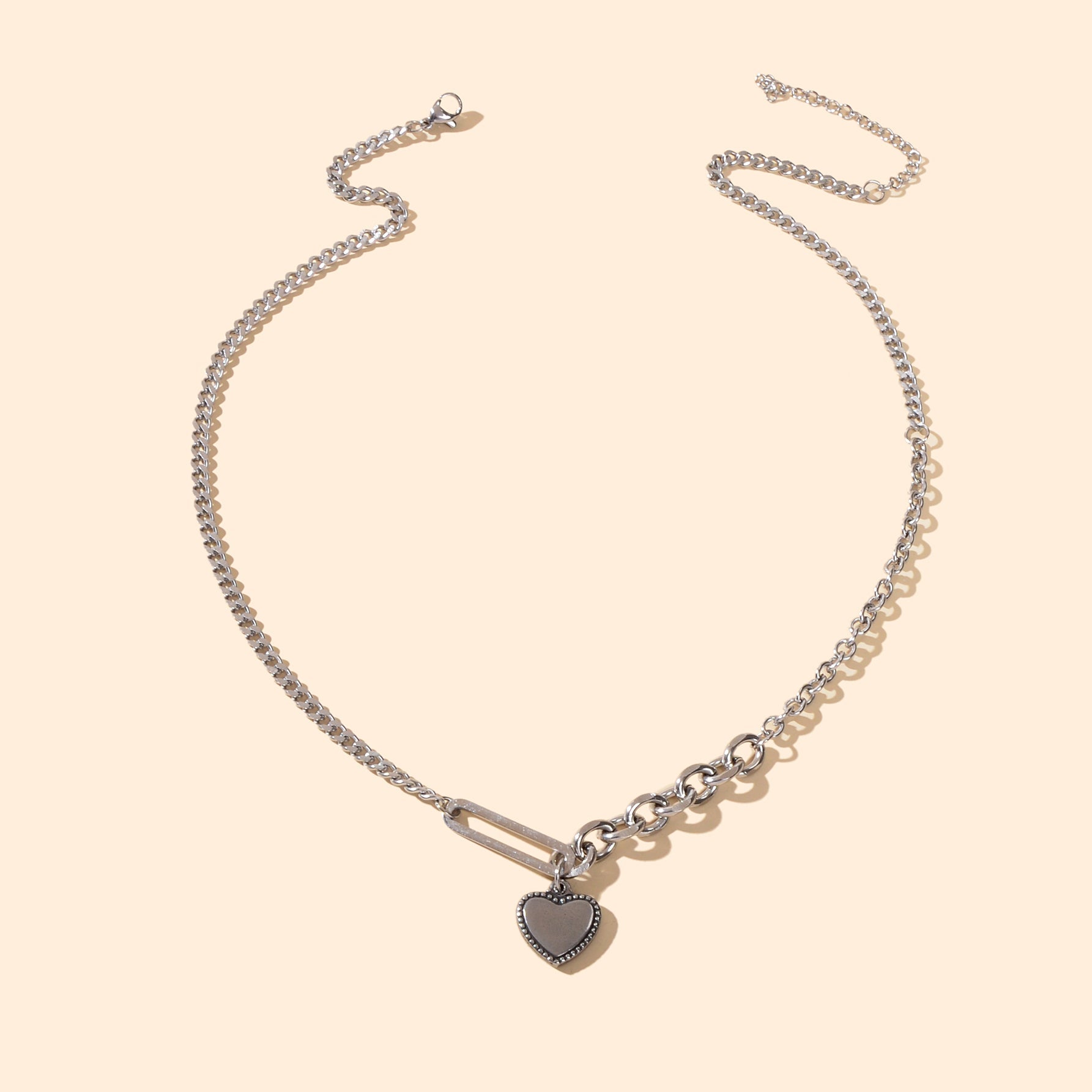 Layered multiple silver chain necklace featuring a polished love heart charm pendant on a display — view 3
