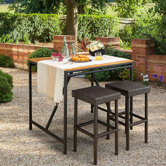 Two brown rattan patio bar stools with steel frames and built in footrests for outdoor dining