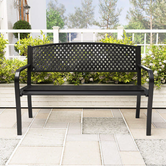 Black metal outdoor patio bench with high backrest and curved armrests in garden setting