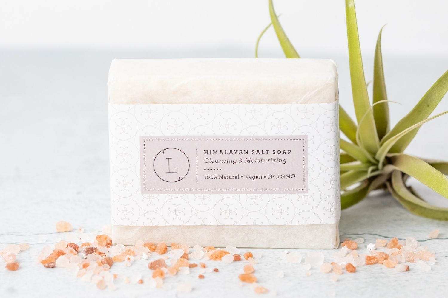 Two natural cold process essential oil soap bars resting inside a reusable cotton drawstring bag — view 5