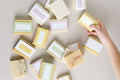 Two natural cold process essential oil soap bars resting inside a reusable cotton drawstring bag