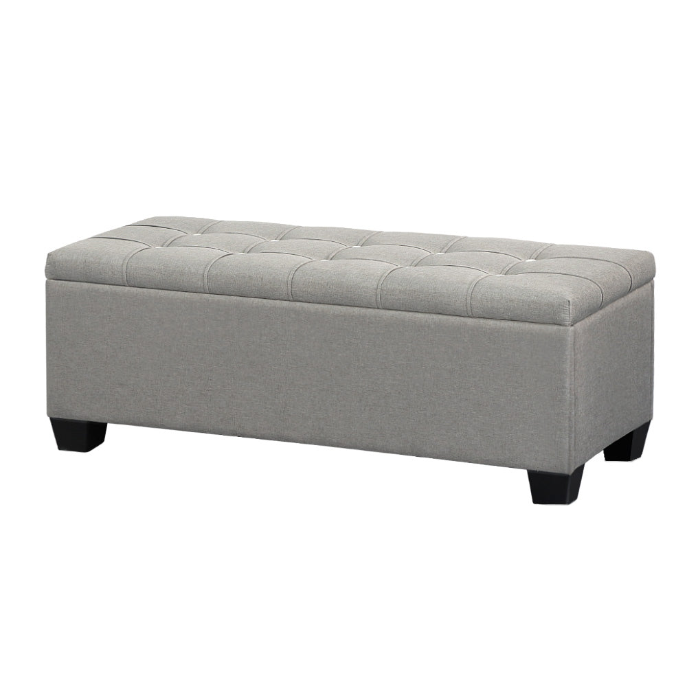Light grey faux linen tufted storage ottoman with a lift-up lid and detachable wooden legs.
