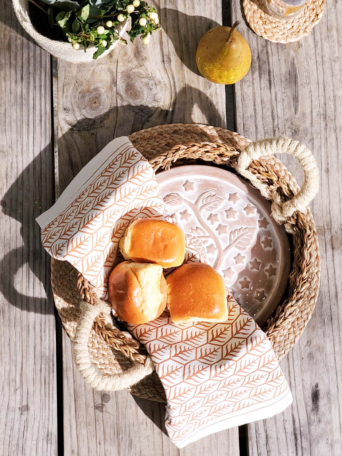 Owl terracotta bread warmer stone in a woven seagrass basket with a printed cotton tea towel — view 3
