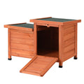 Brown and green wooden outdoor cat house with sloped asphalt roof and drop-down entry ramp